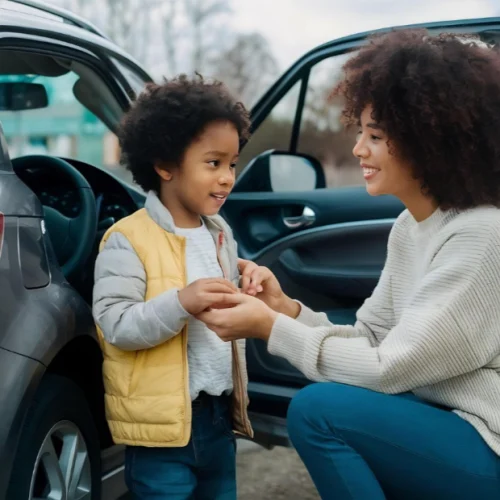 Parent helping a young child during school pickup, representing the Kidz and Keyz passion for secure and caring student dismissal in Charleston schools