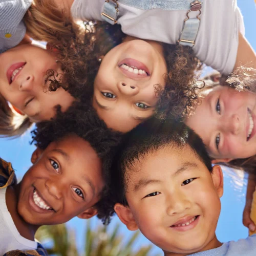 Group of smiling elementary school children together representing the Kidz and Keyz vision for safe and consistent school dismissal across Charleston